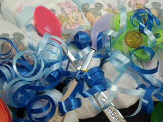 Attach baby spoons to diaper wreath